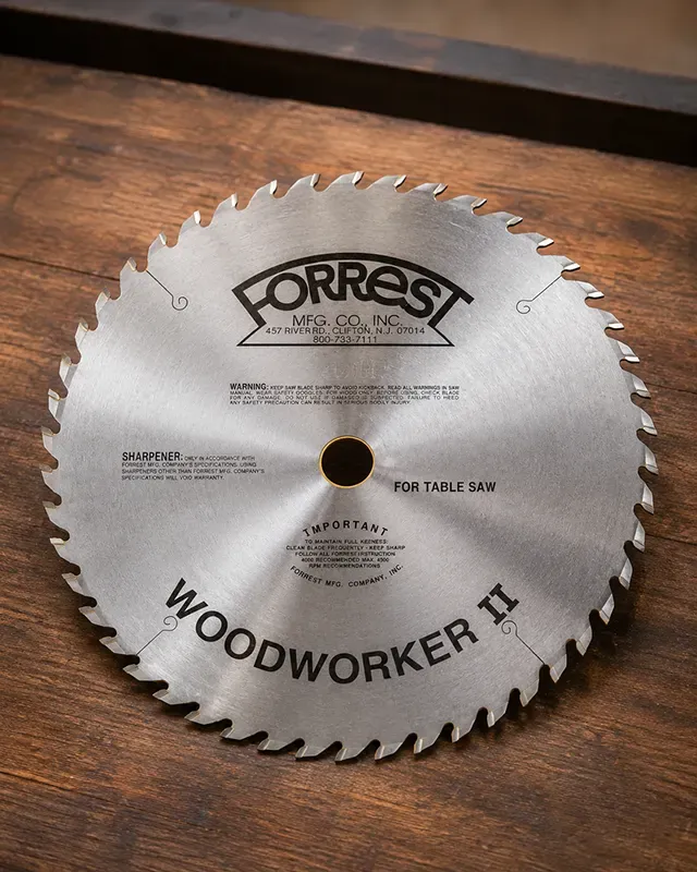 Forrest Woodworker II table saw blade resting on a cast iron table saw top